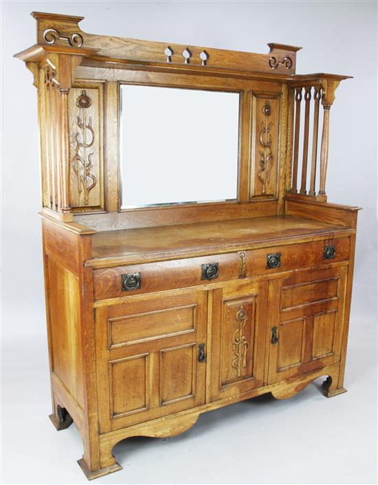An Arts & Crafts carved oak sideboard with raised mirrored back, W. 5ft 8in. D. 1ft 11in. H. 6ft 4in.